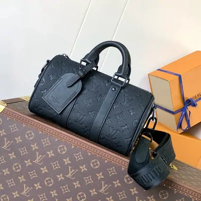 Black embossed travel bag with handles and shoulder strap