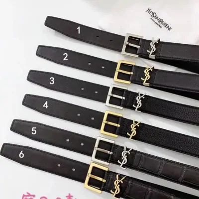 Six black leather belts with gold and silver interlocking letter buckles, numbered one to six