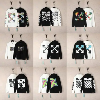 Nine black and white hoodies with large arrow and cross graphic prints on hangers