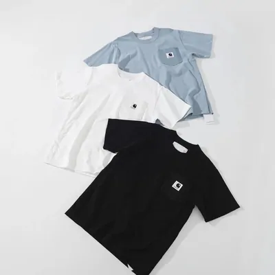 Three pocket T-shirts in light blue, white and black laid flat