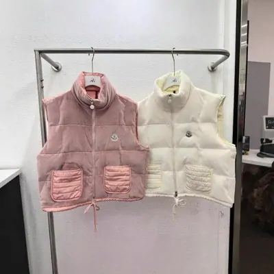 Pink and cream quilted gilet vests on hangers in a fitting room